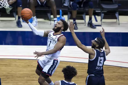 Rj Cole drives in for the layup past the defender in the game against Georgetown at Gampel Pavilion on March 6th 2021