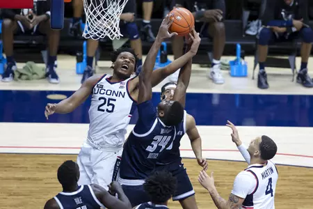 Josh Carlton rises for the rebound in the game against Georgetown at Gampel Pavilion on March 6th 2021