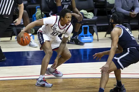 Brendan adams dribbles in front of the defender in the game against Georgetown at Gampel Pavilion on March 6th 2021