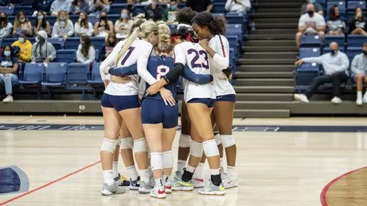 The volleyball team in a huddle before the start of a match