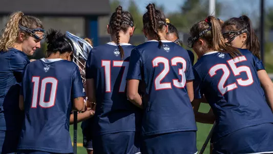 The women's lacrosse team huddling before the Yale game