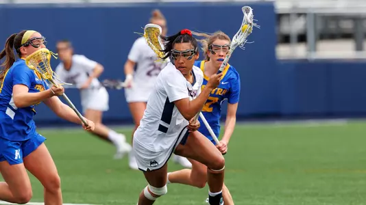 Sydney Watson cradling the ball with defenders nearby