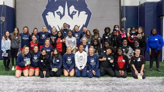 The UConn women's lacrosse team and EMHS students