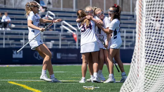 Members of the women's lacrosse team celebrating after Emily Schillinger's first career goal