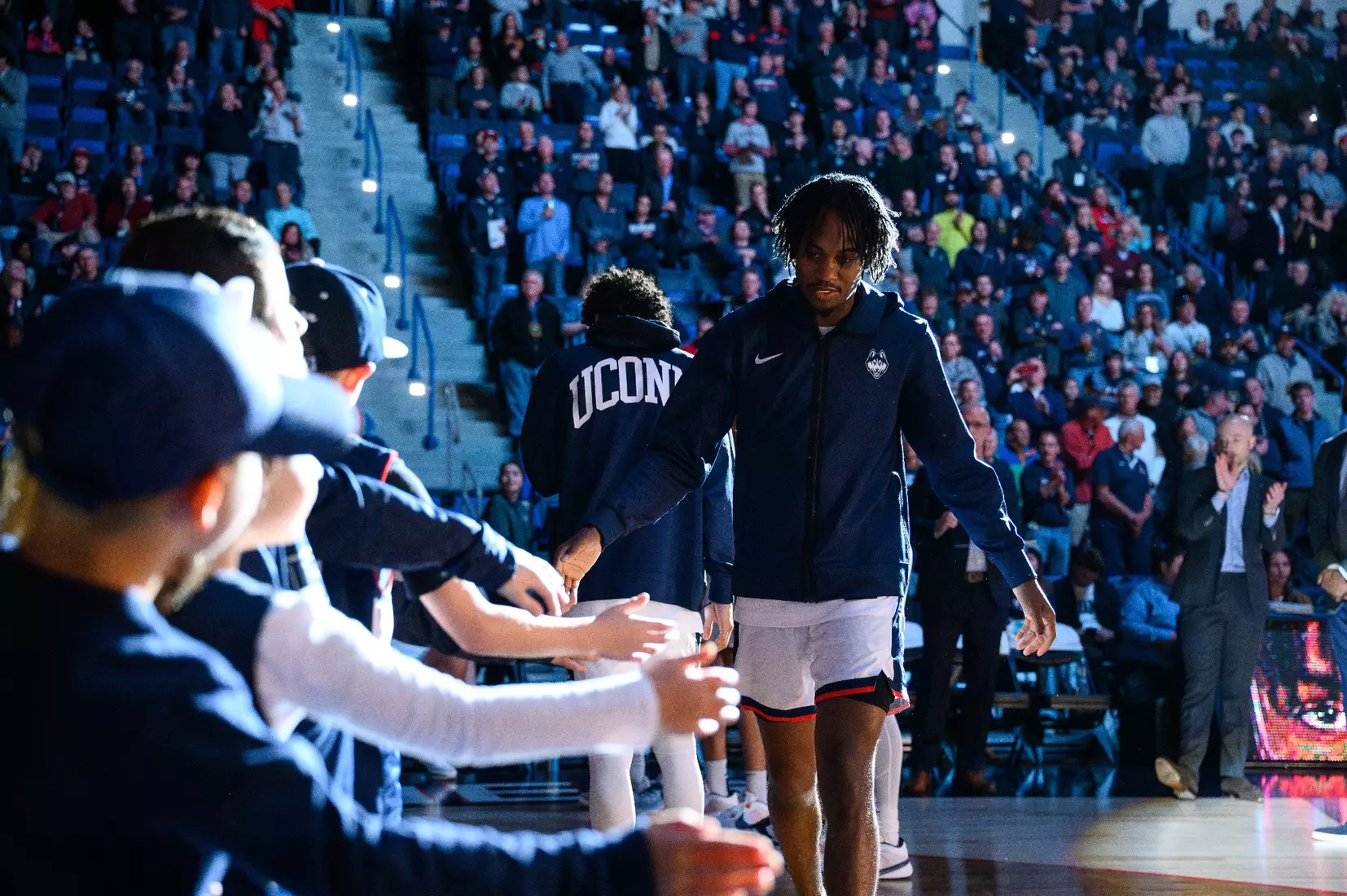 Tristen Newton greets Junior Husky Club members during the starting lineups.
