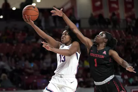 Connecticut's Christyn Williams (13) goes up for a shot as Houston's Bria Patterson (1) defends during the second half of an NCAA college basketball game Saturday, Feb. 29, 2020, in Houston. Connecticut won 92-40. (AP Photo/David J. Phillip)