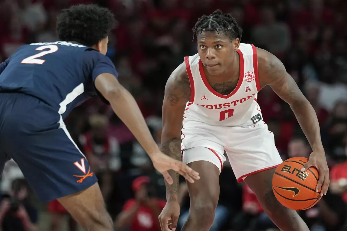 Houston guard Marcus Sasser (0) dribbles as Virginia guard Reece Beekman defends during the first half of an NCAA college basketball game, Tuesday, Nov. 16, 2021, in Houston. (AP Photo/Eric Christian Smith)