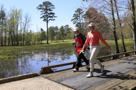 Karen Fredgaard of Denmark and her caddie walk over the bridge on the No. 4 hole during Round 2 of the Augusta National Women's Amateur, Thursday, April 1, 2021.