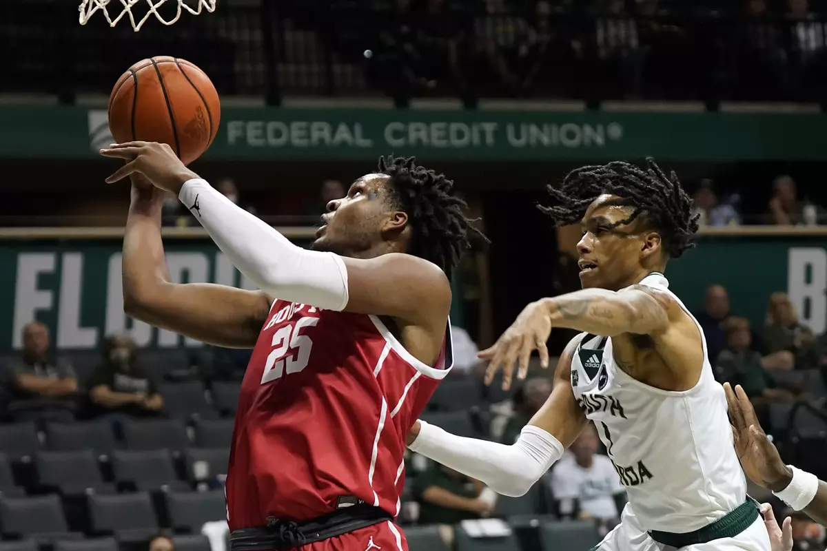 Houston center Josh Carlton (25) shoots around South Florida guard Javon Greene (1) during the second half of an NCAA college basketball game Wednesday, Jan. 5, 2022, in Tampa, Fla. (AP Photo/Chris O'Meara)