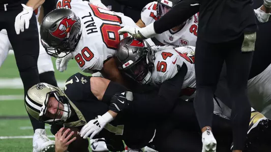 Oct 26, 2025; New Orleans, Louisiana, USA; New Orleans Saints tight end Taysom Hill (7) reacts after a tackle by Tampa Bay Buccaneers defensive end Logan Hall (90) and outside linebacker Lavonte David (54) during the fourth quarter at Caesars Superdome. Mandatory Credit: Stephen Lew-Imagn Images