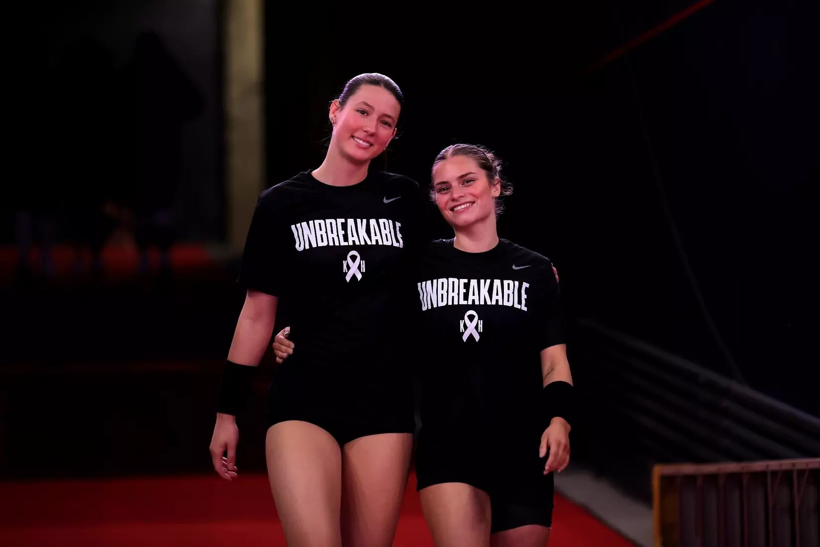 Alana Torres-Rivera and Aubrey Sears walk down the tunnel to the court pregame.