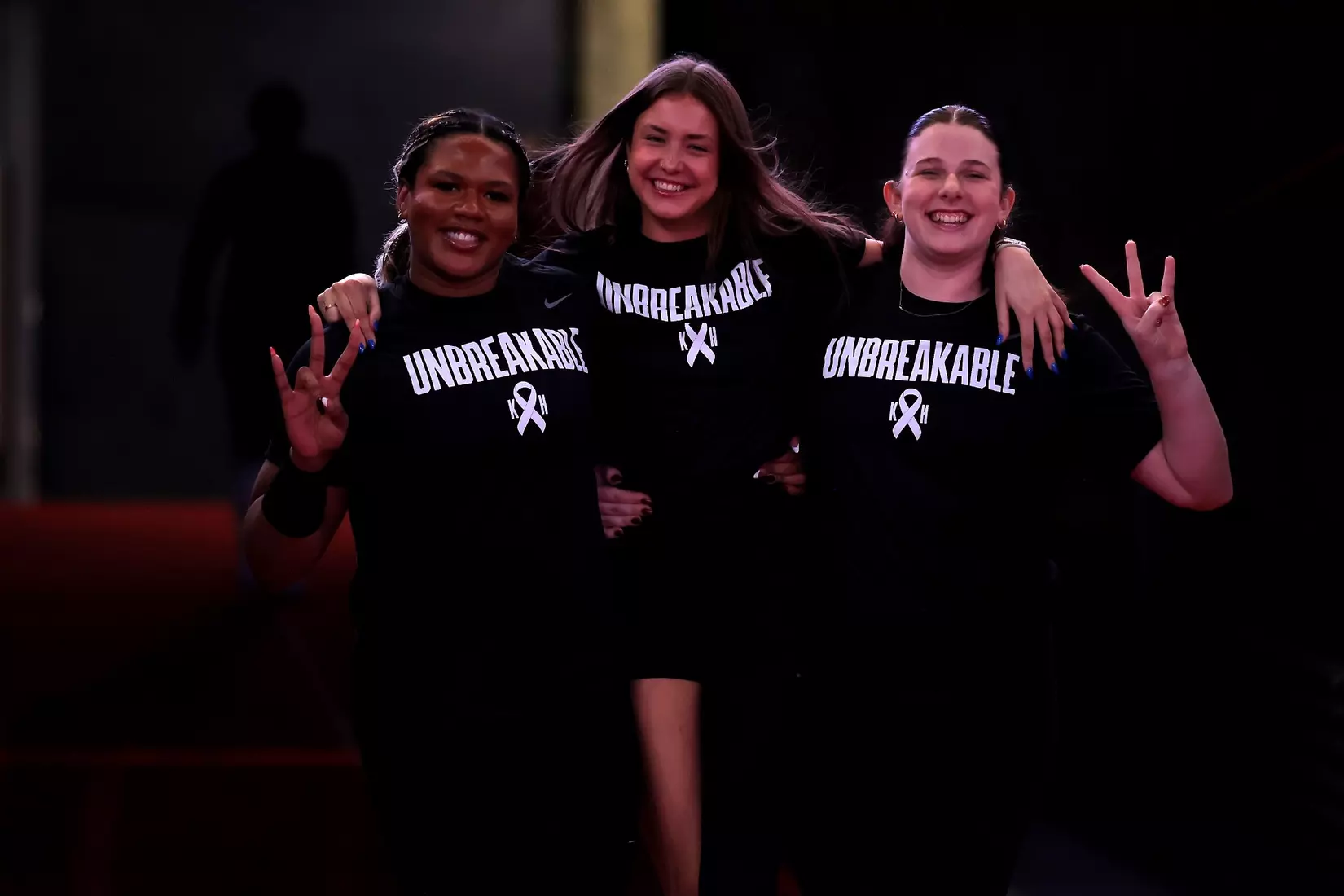 Tara Greenberry, Lily Barron and Addisyn Pohl walk down the tunnel to the court pregame.