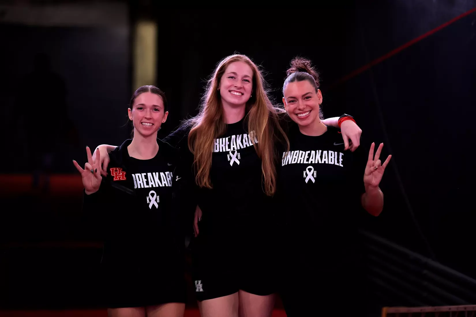 Halle Schroder, Kellen Morin and Aidan Conner walk down the tunnel to the court pregame.