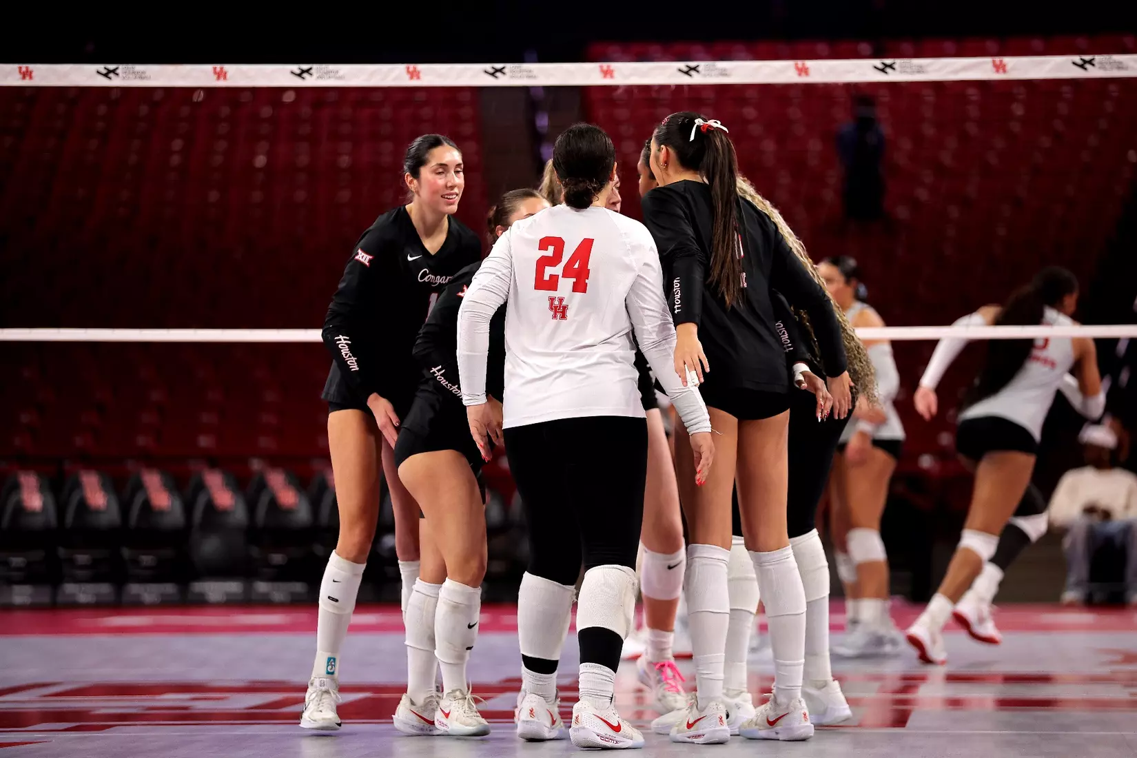 The Houston Volleyball team huddles together after a point.