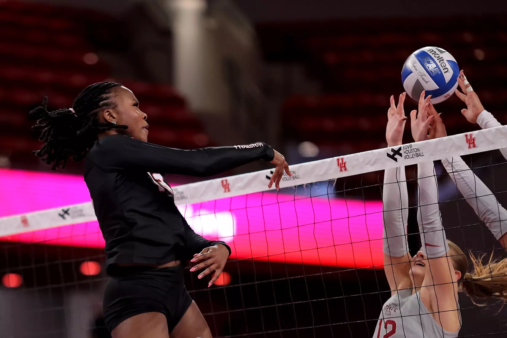 Barakat Rahmon attacks a volleyball against Iowa State defenders.