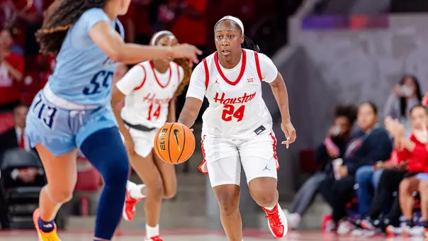 Guard Shun'teria Anumele dribbles basketball against Rice defender