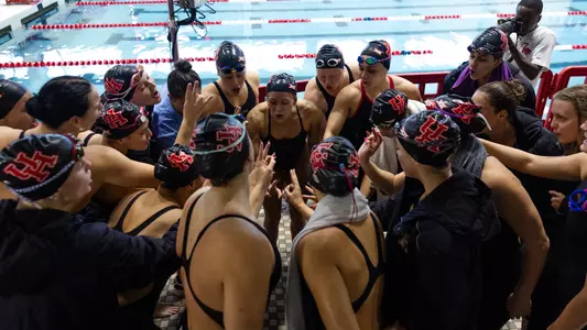 The UH Cougar Swim Team chants together as a team before starting the preliminary swimming events