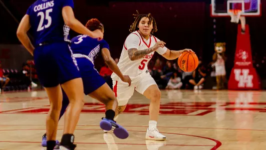 Kateri Poole dribbling basketbball with High Point defender in front of her