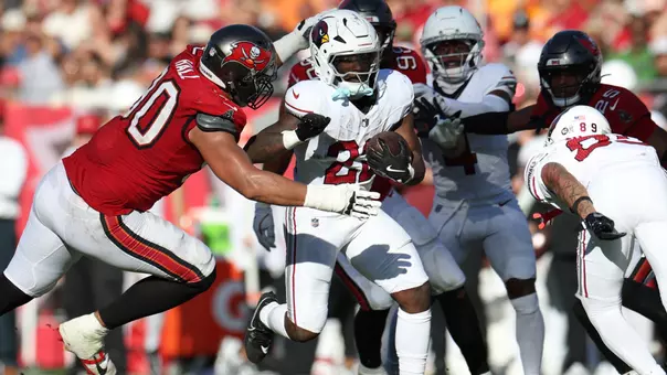 Nov 30, 2025; Tampa, Florida, USA; Arizona Cardinals running back Michael Carter (22) runs against Tampa Bay Buccaneers defensive end Logan Hall (90) during the second half at Raymond James Stadium. Mandatory Credit: Nathan Ray Seebeck-Imagn Images