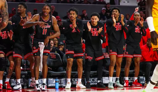Reserve Houston Men's Basketball players clap and cheer for their on-court teammates