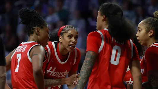 Women's Basketball players talking in huddle in game at Kansas State