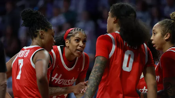 Women's Basketball players talking in huddle in game at Kansas State