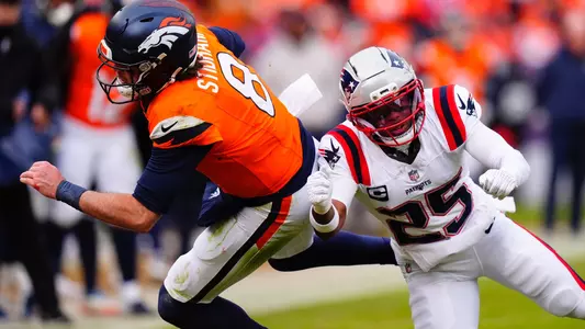 Jan 25, 2026; Denver, CO, USA; Denver Broncos quarterback Jarrett Stidham (8) rushes the ball past New England Patriots cornerback Marcus Jones (25) during the first half in the 2026 AFC Championship Game at Empower Field at Mile High. Mandatory Credit: Ron Chenoy-Imagn Images