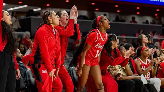 Women's basketball bench celebrating during game