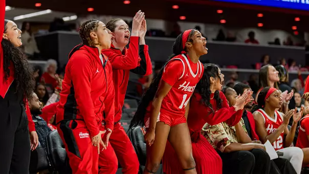 Women's basketball bench celebrating during game