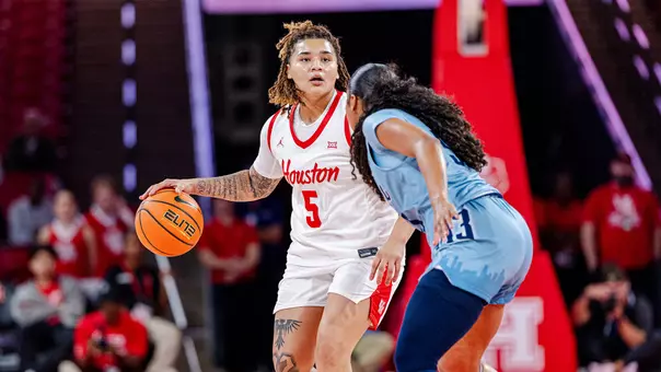 Kateri Poole dribbling basketball with Rice defender in front of her