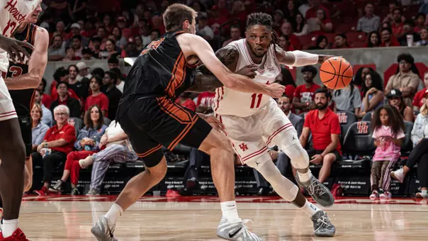 joseph tugler dribbles basketball while being defended