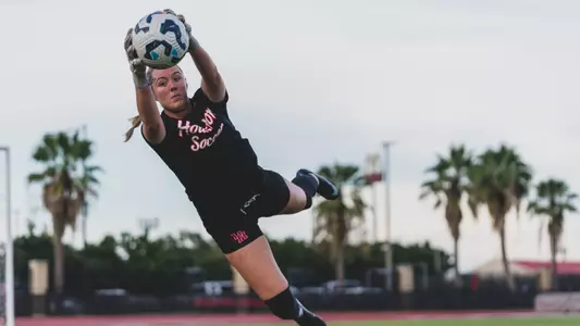 Sierra McCluer dives and grabs a soccer ball