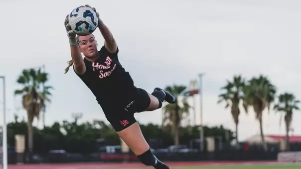 Sierra McCluer dives and grabs a soccer ball