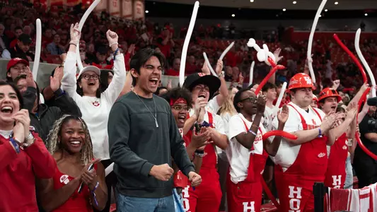 Fans and students cheering in The Cage inside Fertitta Center
