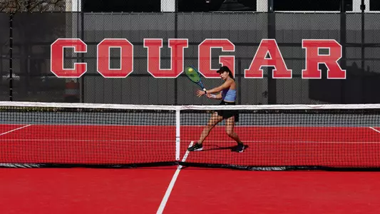 Tennis player in front of banner that says Cougars