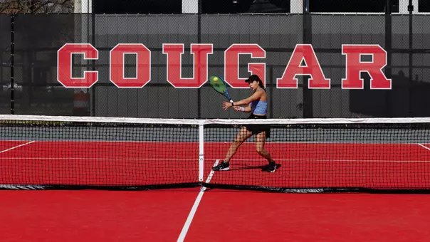 Tennis player in front of banner that says Cougars