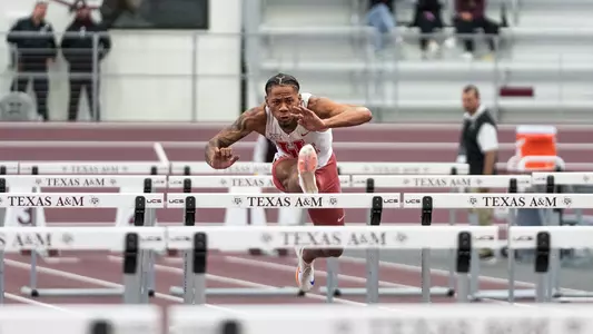 Jamar Marshall Jr. jumping over hurdle with right foot extended and arms extended