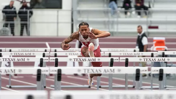 Jamar Marshall Jr. jumping over hurdle with right foot extended and arms extended