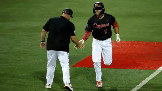 Xavier Perez high fives third-base coach Kyle Cheeseborough as he rounds the bases.