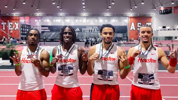 Men's 4x400-meter relay of Trey East III, Dominic Harper, King Taylor and Damarien Jacobs holding their silver medals and putting their Cougar paws up