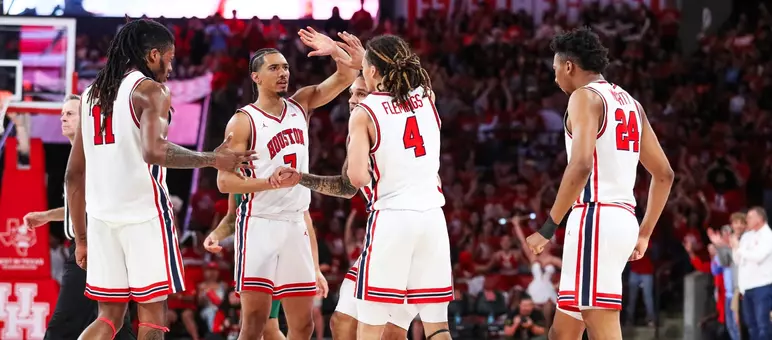 Cougars exchange high five in team huddle in Fertitta Center