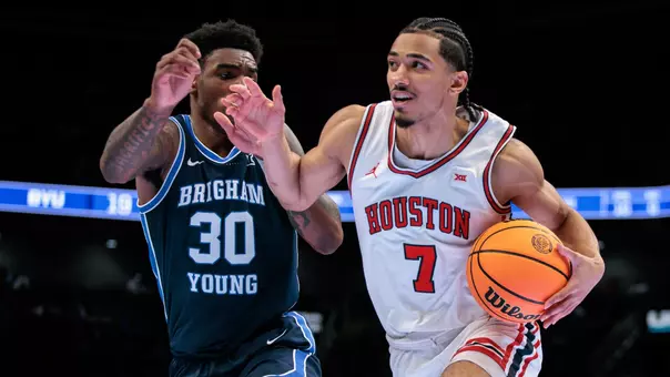 Milos Uzan drives the basketball while being guarded