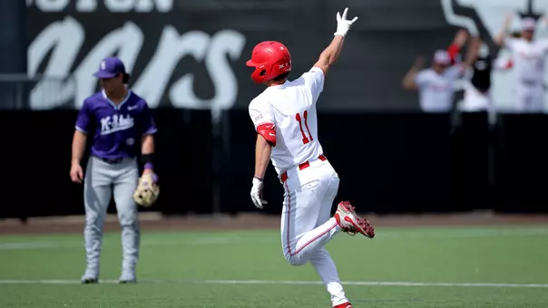 Tyler Cox salutes the bullpen while rounding the bases.