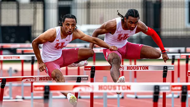 Noah Hanson and Anthony Trucks with their right legs going over the hurdle