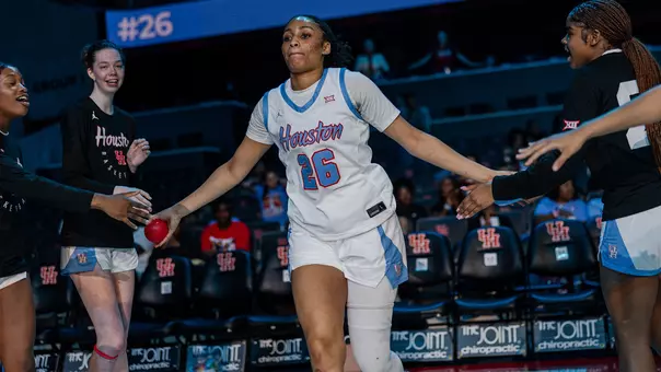Jorynn Ross running towards teammates during starting lineups with mini basketball in hand