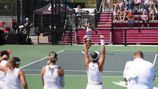 tennis player celebrating with people celebrating in foreground