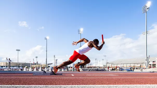 Track & Field athlete with a baton in hand at 44 Farms Invitational