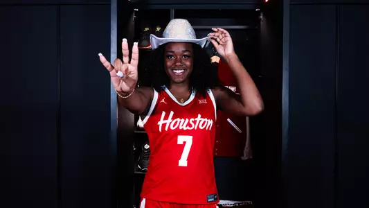 Kaelyn Hamilton wearing cowboy hat and with Coogs hand sign in front of her