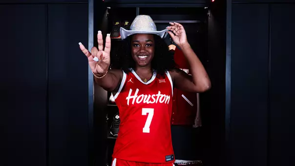 Kaelyn Hamilton wearing cowboy hat and with Coogs hand sign in front of her