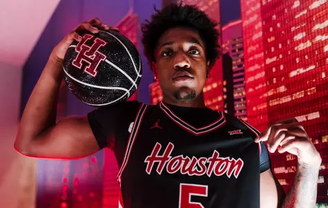 Braden East pops his black HOuston jersey while holding a glittered basketball